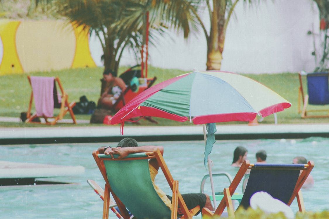 A happy person lounges at the pool