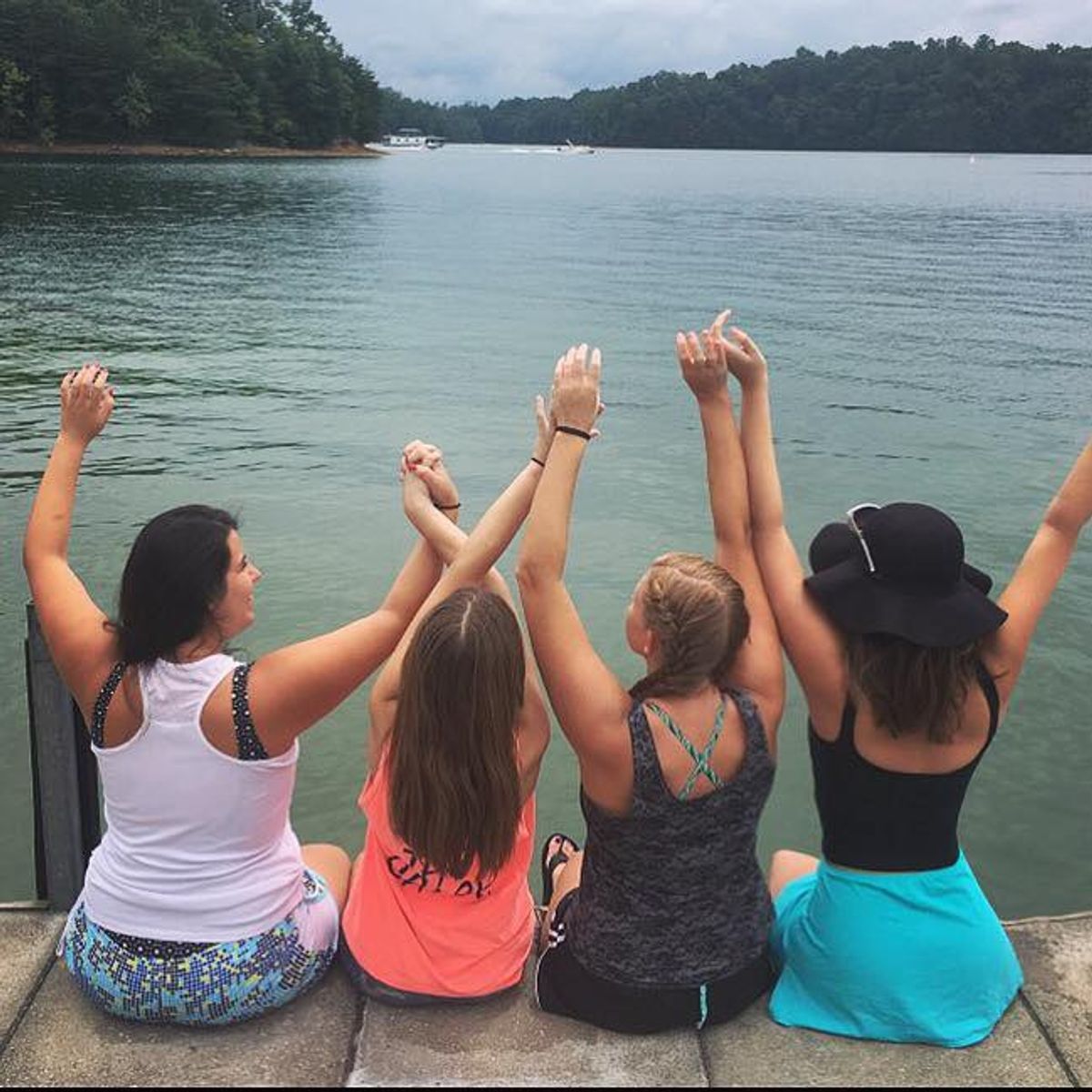 the baby of the friend group holds hands with her friends